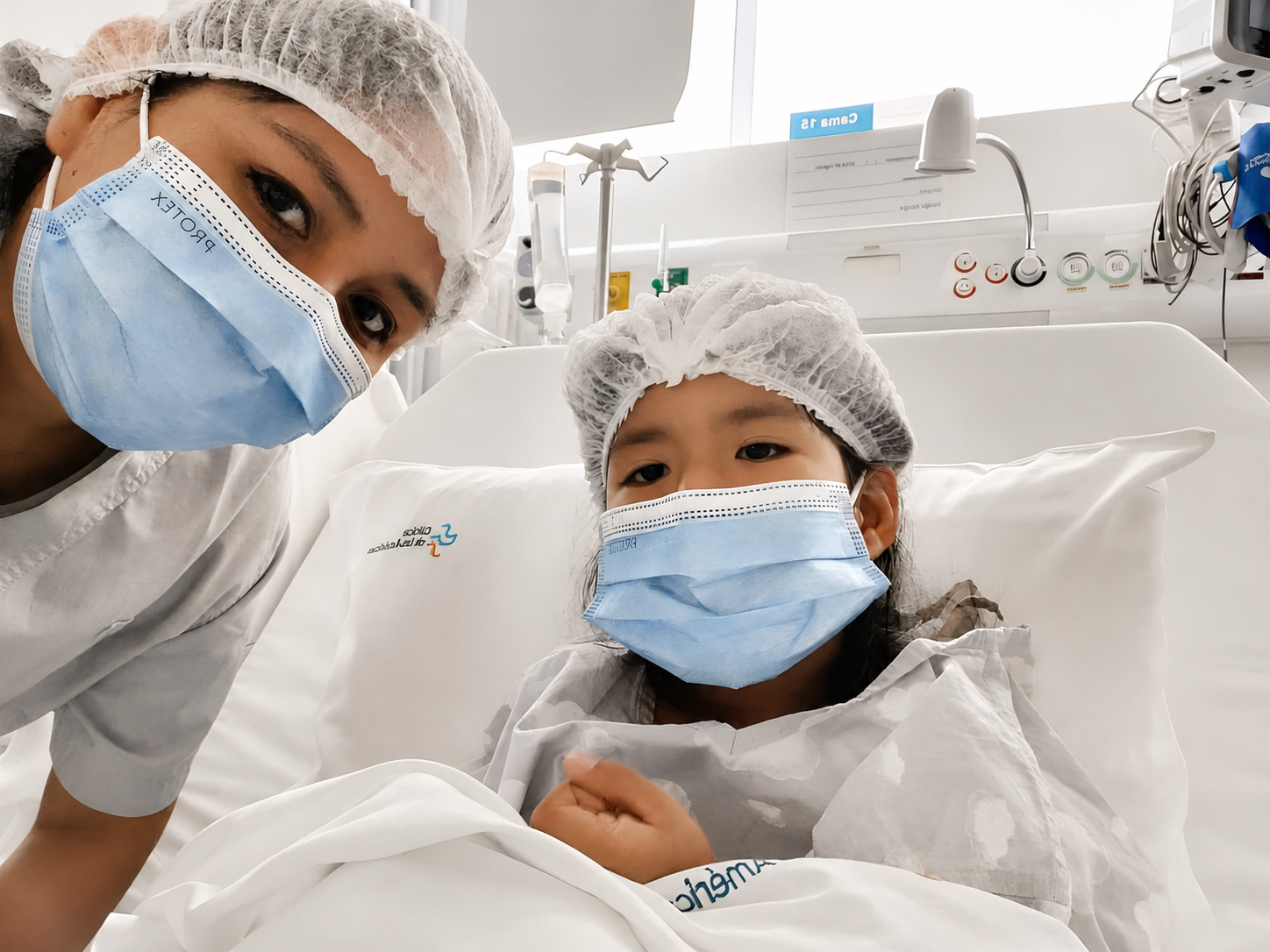 Paciente pediátrica acompañada por una profesional de salud en una unidad de cuidados intensivos